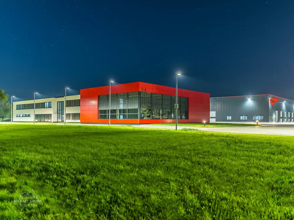 Das KROLL-Werk in Hünxe bei Nacht, beleuchteter roter Verwaltungsbau und Produktionshalle