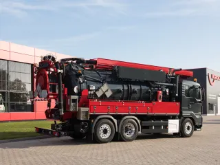Rot-schwarzes Saug-Spülfahrzeug mit Teleskopausleger in Fahrstellung, Seitenansicht vor dem KROLL-Werk