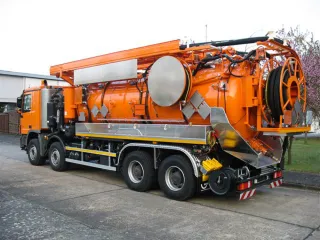 Orangefarbenes Vierachs-Saugfahrzeug mit Schlauchhaspel am Heck