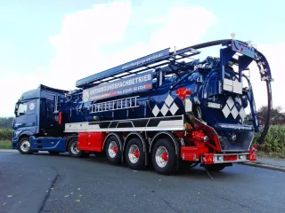 Blauer Dreiachs-Saug-Sattelauflieger mit Saugausleger, Heckansicht