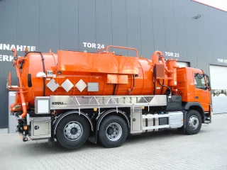 Orangefarbenes Dreiachs-Saugfahrzeug mit Edelstahl-Unterbau vor der Werkshalle