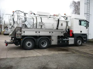 Weißes Saugfahrzeug mit Edelstahl-Werkzeugkästen in Seitenansicht