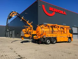 Oranges KROLL-Saug-Spülfahrzeug mit Simultanausleger vor dem KROLL-Werk, Ausleger mit Saug- und Hochdruckschlauch nach hinten ausgeschwenkt