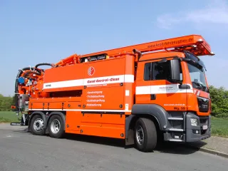 Orangefarbenes Saug-Spülfahrzeug mit Wasserrückgewinnung in Kundenbeschriftung, Seitenansicht
